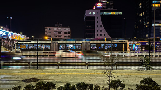 Night Metrobüs at Mecidiyeköy through the wire fence